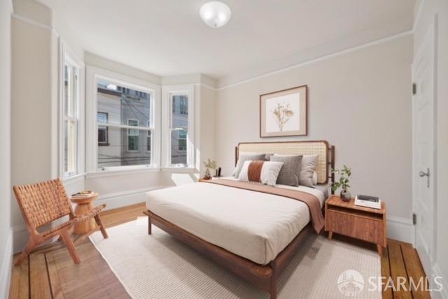 bedroom with baseboards and wood finished floors