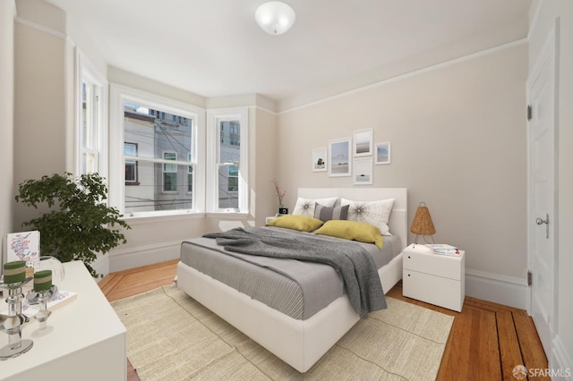 bedroom featuring baseboards and wood finished floors