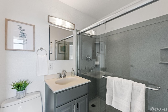 bathroom featuring vanity, toilet, and an enclosed shower