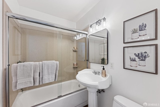 bathroom featuring shower / bath combination with glass door and toilet