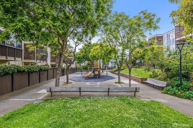 view of home's community with a playground and a yard