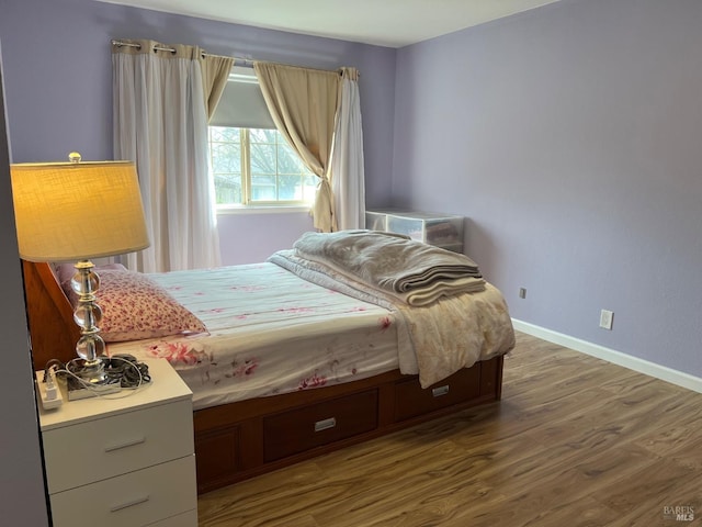 bedroom featuring baseboards and wood finished floors