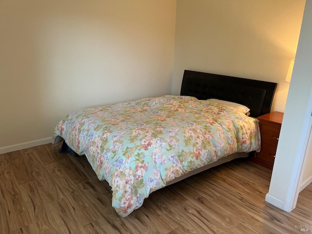 bedroom featuring wood finished floors and baseboards