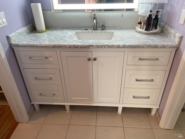 bathroom with baseboards, vanity, and tile patterned floors