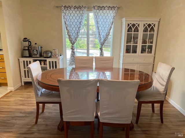 dining area with baseboards and wood finished floors