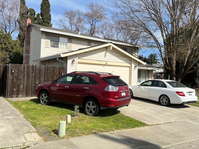 view of front facade featuring an attached garage, a chimney, fence, and concrete driveway