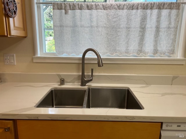 interior details with light stone counters and a sink