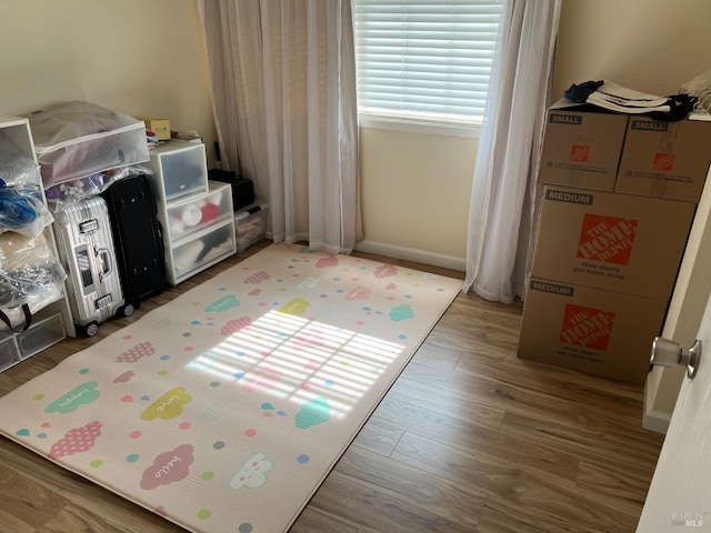 game room with baseboards and wood finished floors