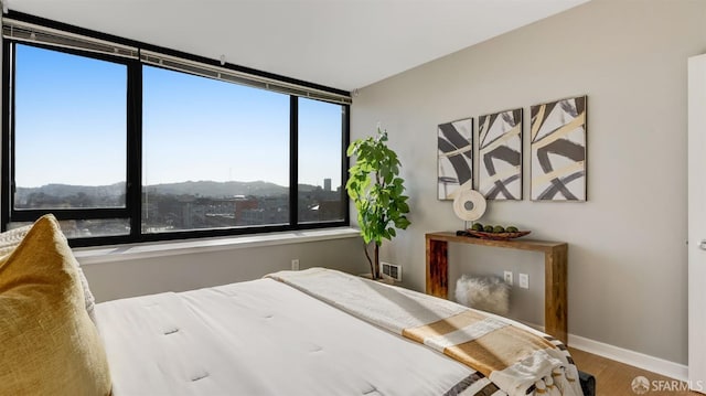 bedroom with baseboards and wood finished floors