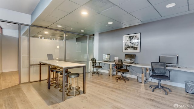 office with a drop ceiling, baseboards, and wood finished floors