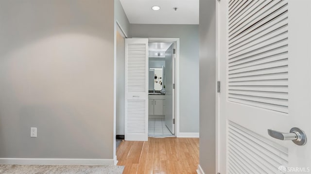 hallway with light wood-style floors and baseboards