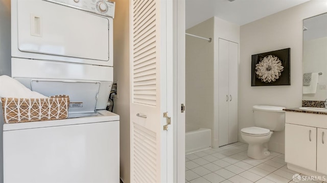 laundry room featuring stacked washer / drying machine, a sink, and light tile patterned floors