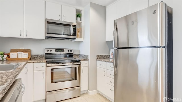 kitchen with stainless steel appliances, light tile patterned flooring, open shelves, and white cabinetry