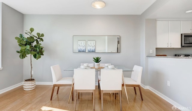 dining room with light wood-type flooring and baseboards