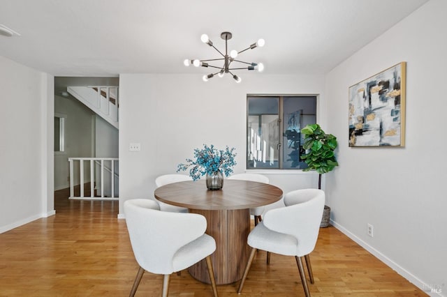 dining space featuring hardwood / wood-style floors and a notable chandelier