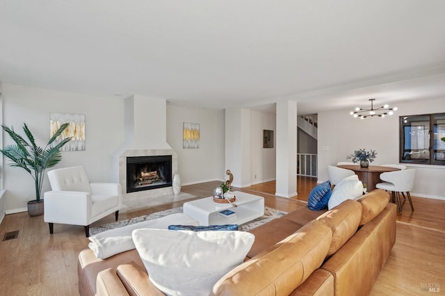 living room with light wood-type flooring and an inviting chandelier