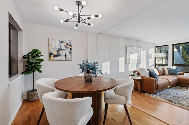 dining space featuring a notable chandelier and light wood-type flooring