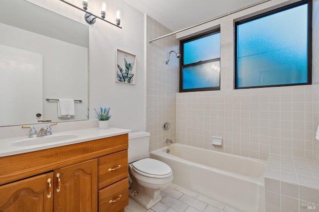 full bathroom featuring tile patterned floors, vanity, toilet, and tiled shower / bath combo