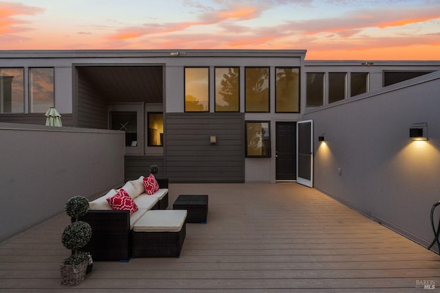 deck at dusk featuring outdoor lounge area