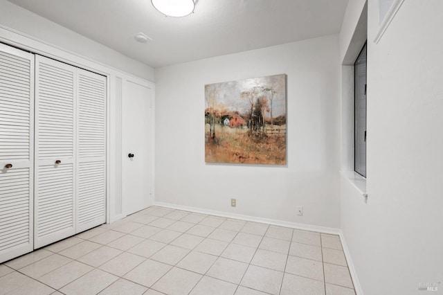 unfurnished bedroom with light tile patterned floors and a closet