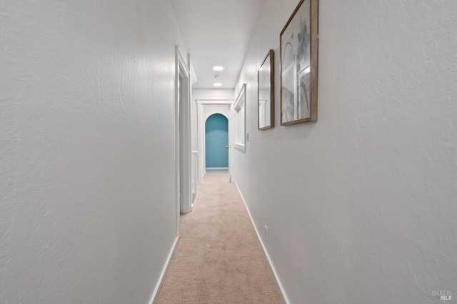 hall with light colored carpet