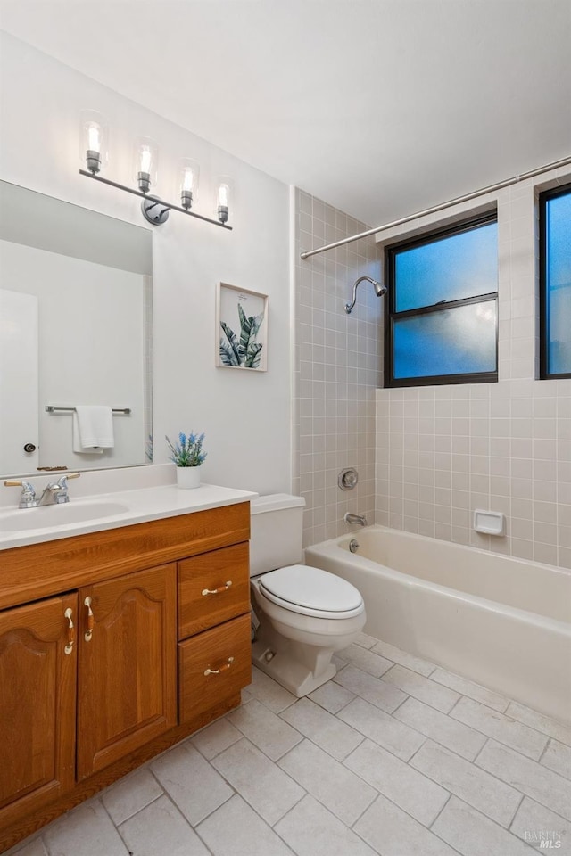 full bathroom featuring tile patterned floors, vanity, toilet, and tiled shower / bath combo