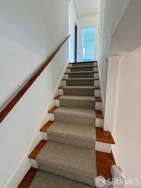 staircase with wood-type flooring