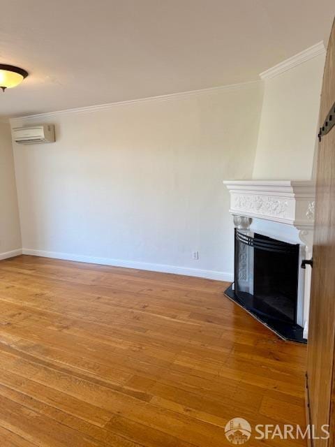 unfurnished living room with crown molding, hardwood / wood-style flooring, and an AC wall unit