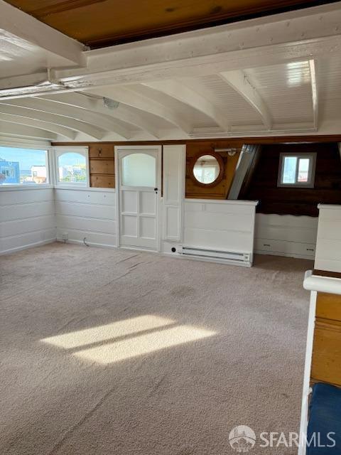 interior space with vaulted ceiling, plenty of natural light, and carpet floors