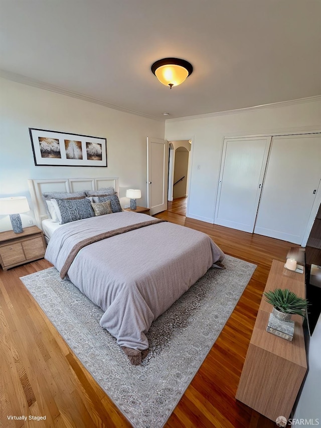 bedroom with crown molding and wood-type flooring