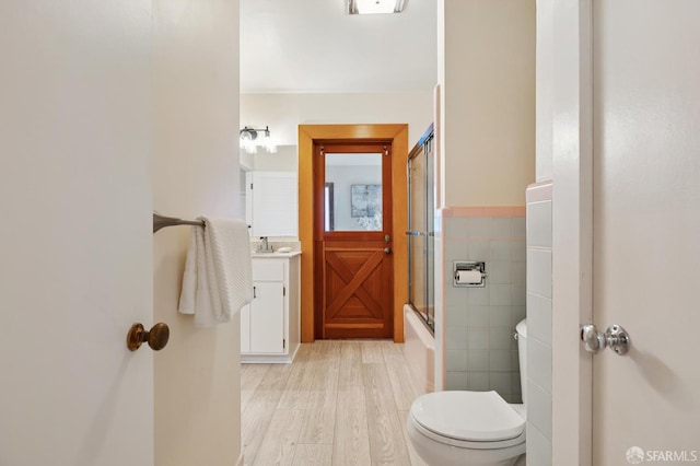 1285 Holloway Ave, San Francisco, CA 94132 - full bathroom with vanity, wood finished floors, tile walls, a wainscoted wall, and enclosed tub / shower combo