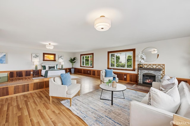 1285 Holloway Ave, San Francisco, CA 94132 - living room featuring a stone fireplace, a wainscoted wall, light wood finished floors, and wood walls