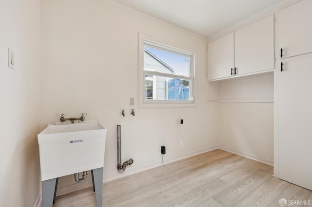 1285 Holloway Ave, San Francisco, CA 94132 - laundry room with cabinet space, ornamental molding, and light wood-style flooring