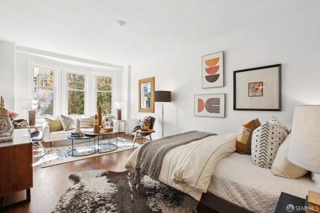 bedroom with radiator and wood finished floors