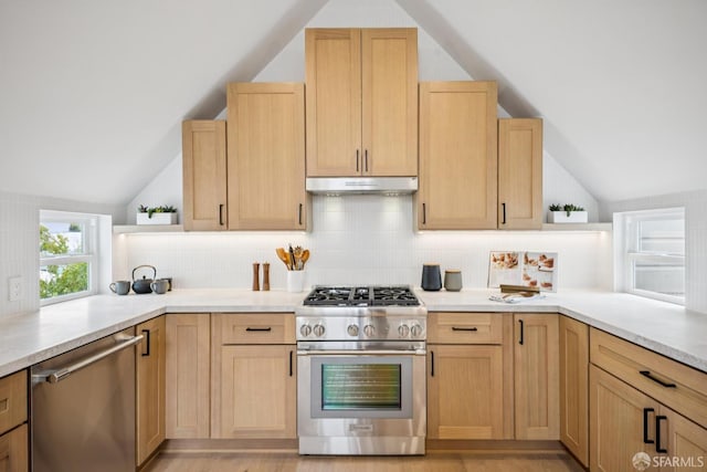 102 Baker St Unit A, San Francisco, CA 94117 - kitchen featuring appliances with stainless steel finishes, lofted ceiling, light brown cabinetry, and tasteful backsplash