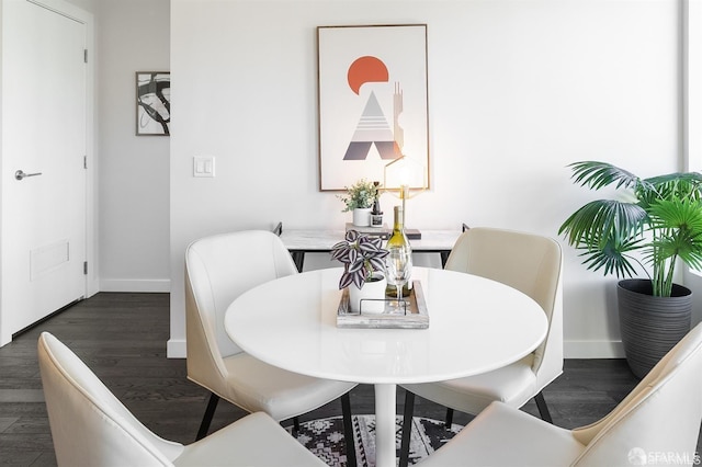 dining space with dark wood-style flooring, visible vents, and baseboards