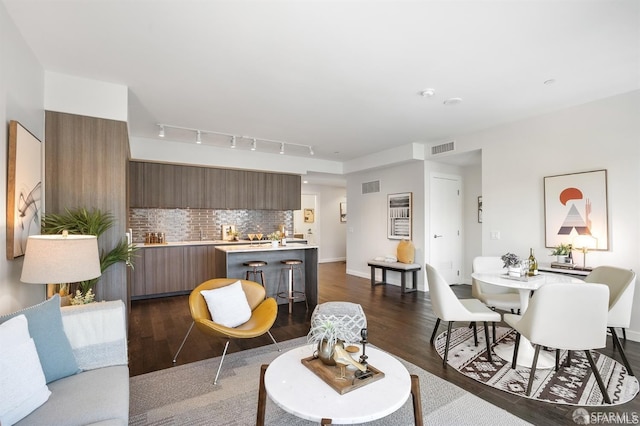 living area with visible vents, dark wood finished floors, and baseboards