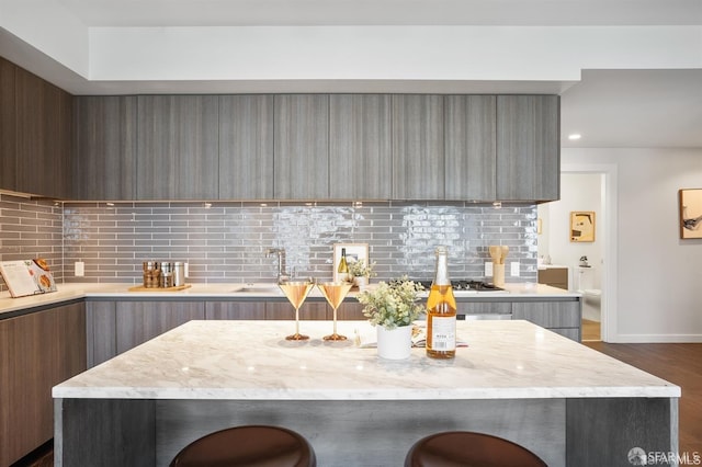 kitchen featuring modern cabinets, a kitchen breakfast bar, and decorative backsplash