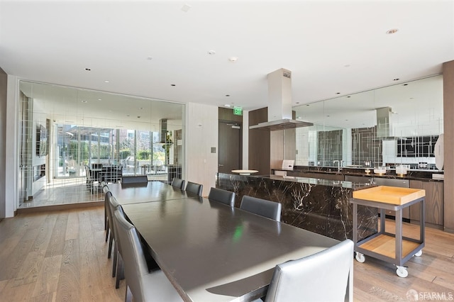 dining room with light wood-type flooring and a wall of windows