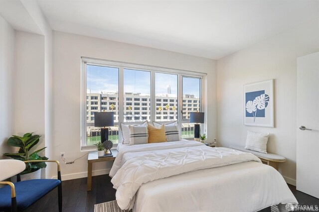 bedroom featuring baseboards and wood finished floors