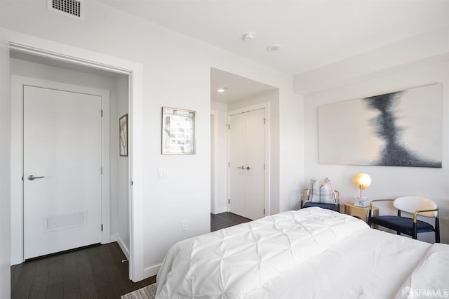 bedroom featuring dark wood-style floors, a closet, visible vents, and baseboards