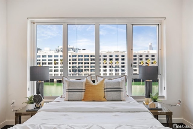 bedroom featuring a view of city and baseboards