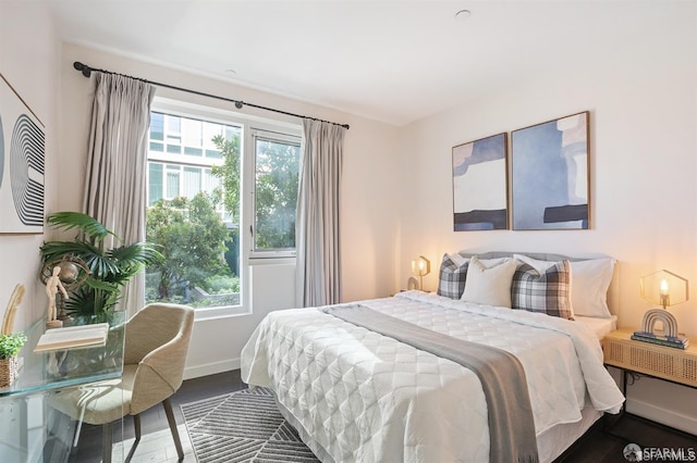 bedroom featuring multiple windows, dark wood finished floors, and baseboards