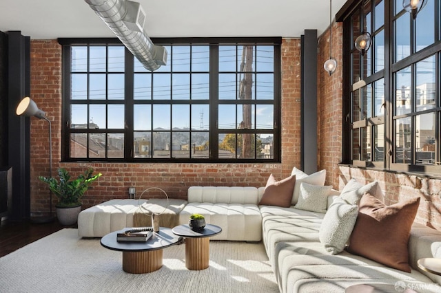 living room featuring hardwood / wood-style flooring and brick wall