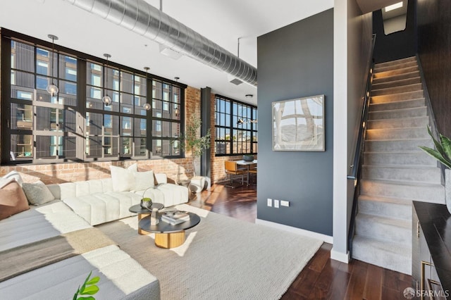 living room with a high ceiling, floor to ceiling windows, and dark wood-type flooring