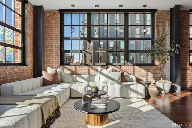 living room with hardwood / wood-style flooring and brick wall