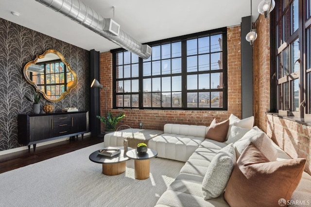 living room featuring hardwood / wood-style flooring and brick wall