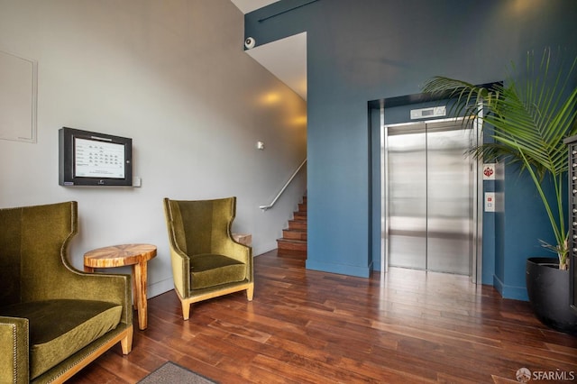 sitting room featuring elevator and dark hardwood / wood-style flooring