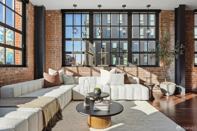 living room with brick wall and hardwood / wood-style floors