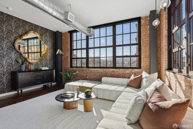 living room with hardwood / wood-style floors and brick wall